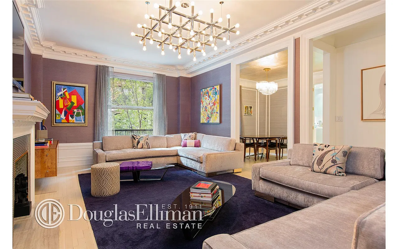 Living room with plum grasscloth walls, sputnik chandelier, sectional sofa and treetop window